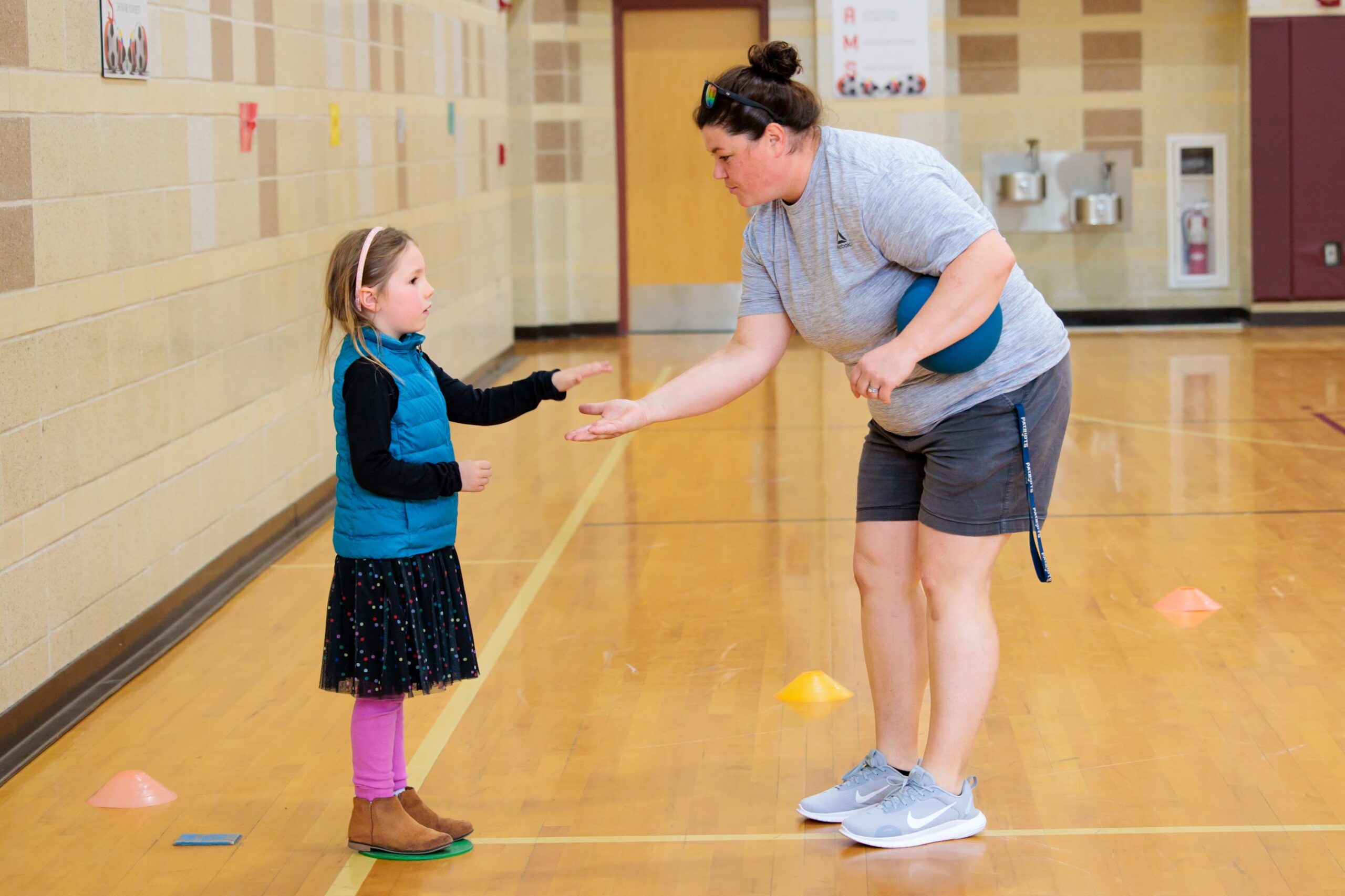 A kindergarten student plays kickball during fitness and health class