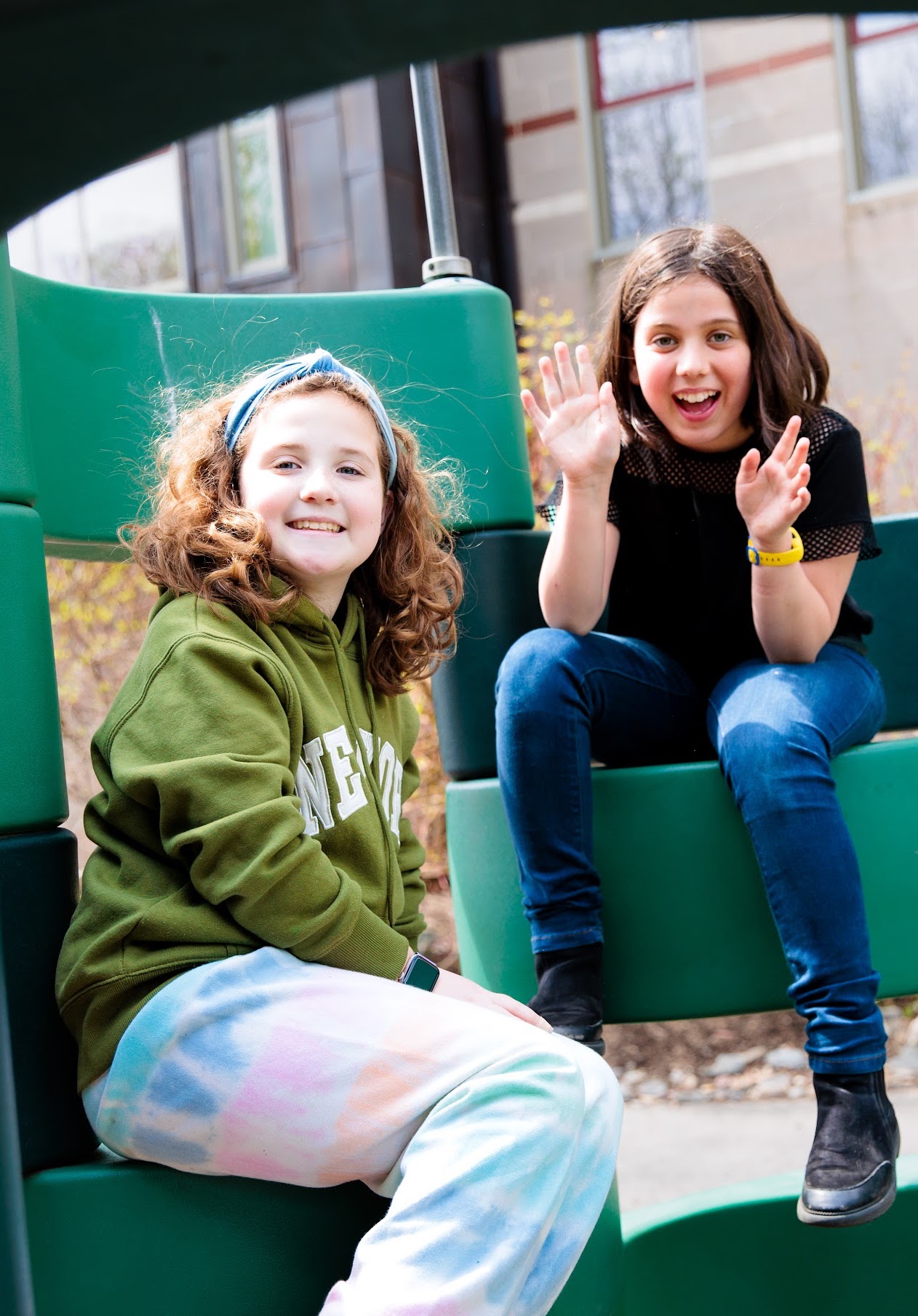 Two students smile while spending time on the playground