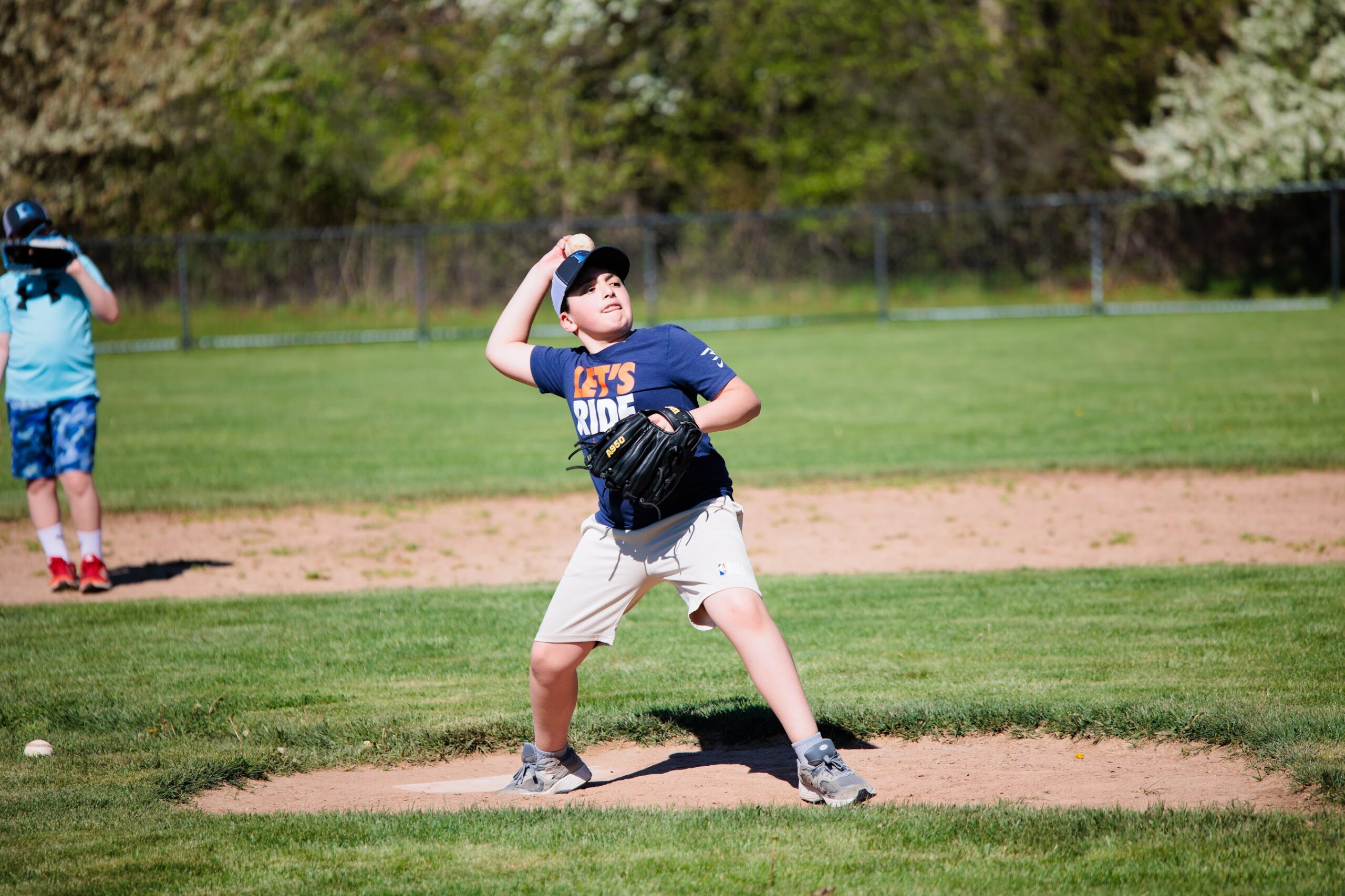 Elementary school student pitches during baseball practice at school
