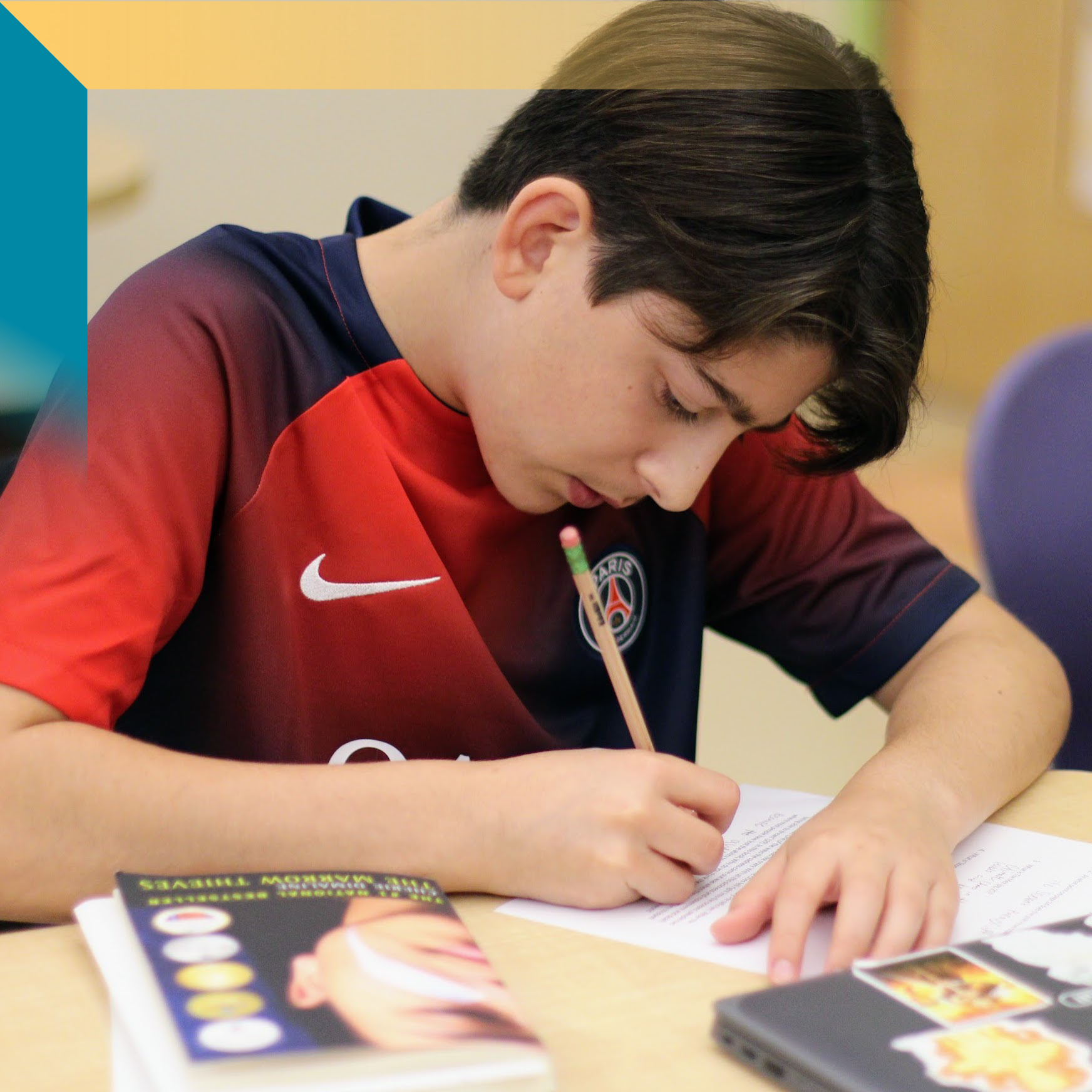 A middle school aged boy leaning over his schoolwork