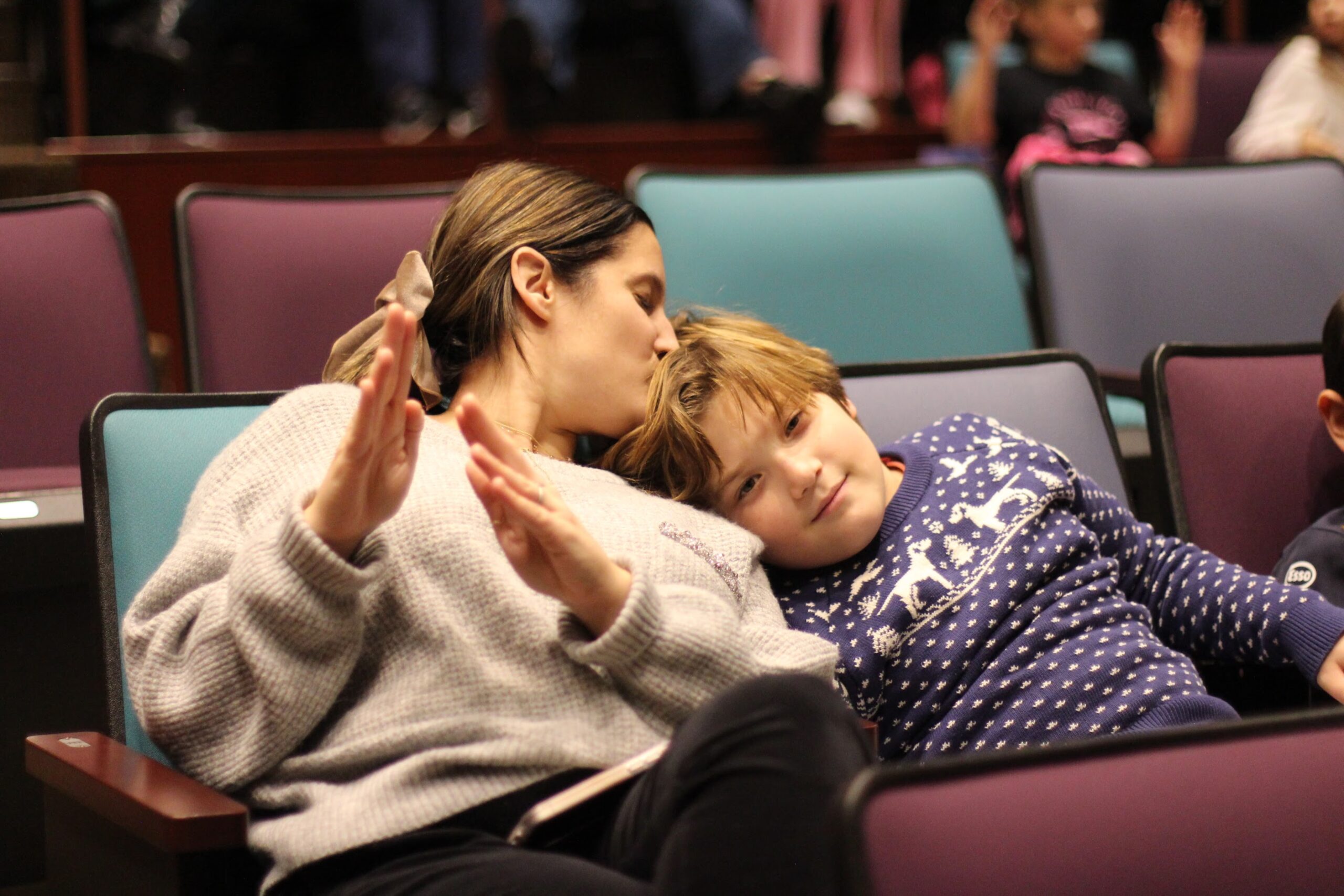 A parent kisses her student's head during Kabbalat Shabbat